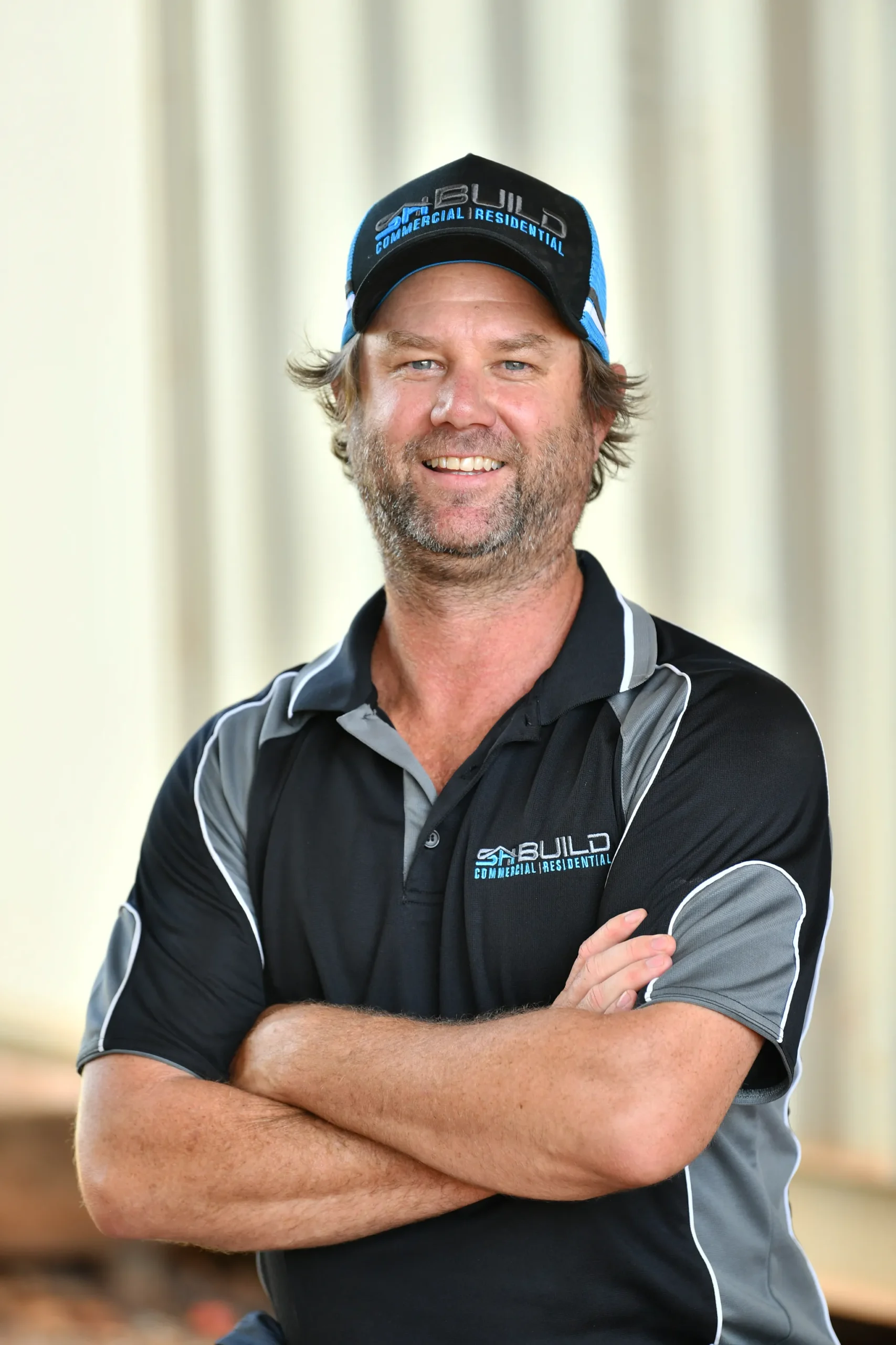 Smiling man wearing a black work polo