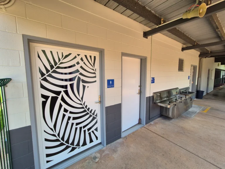 Bathroom entry with decorative leaf design door.