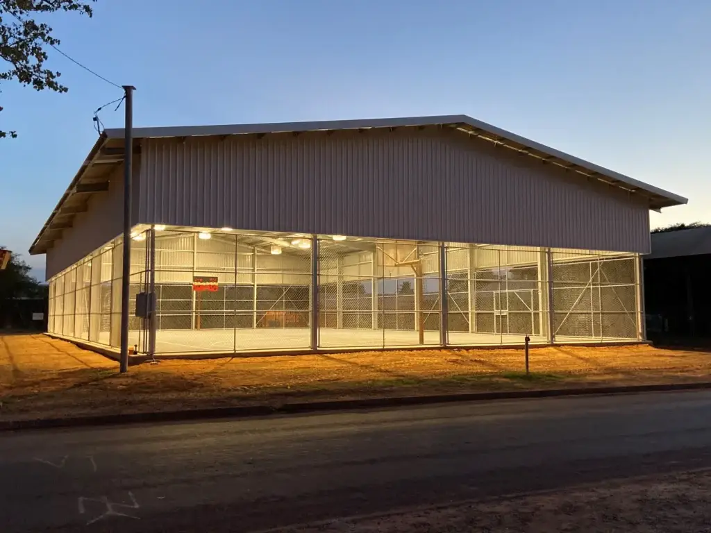 Basketball court building illuminated at dusk