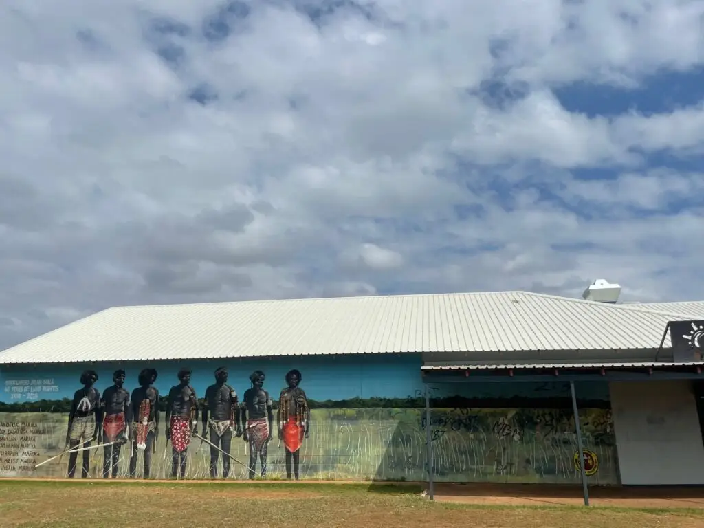 Mural depicting Indigenous Australians on building wall.