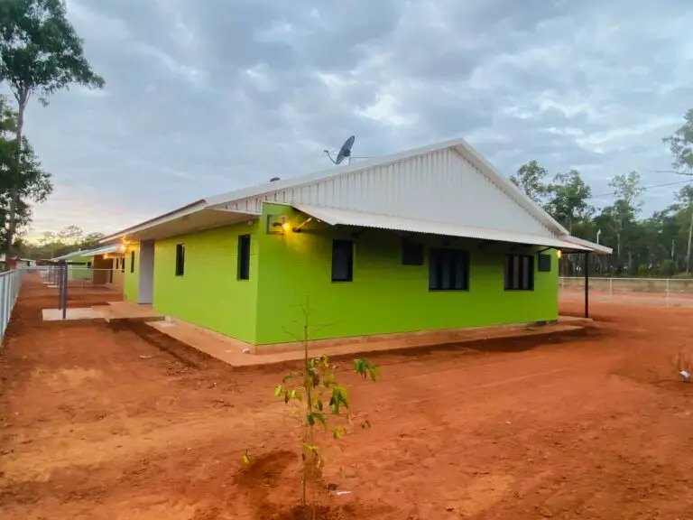 Bright green rural house on red dirt