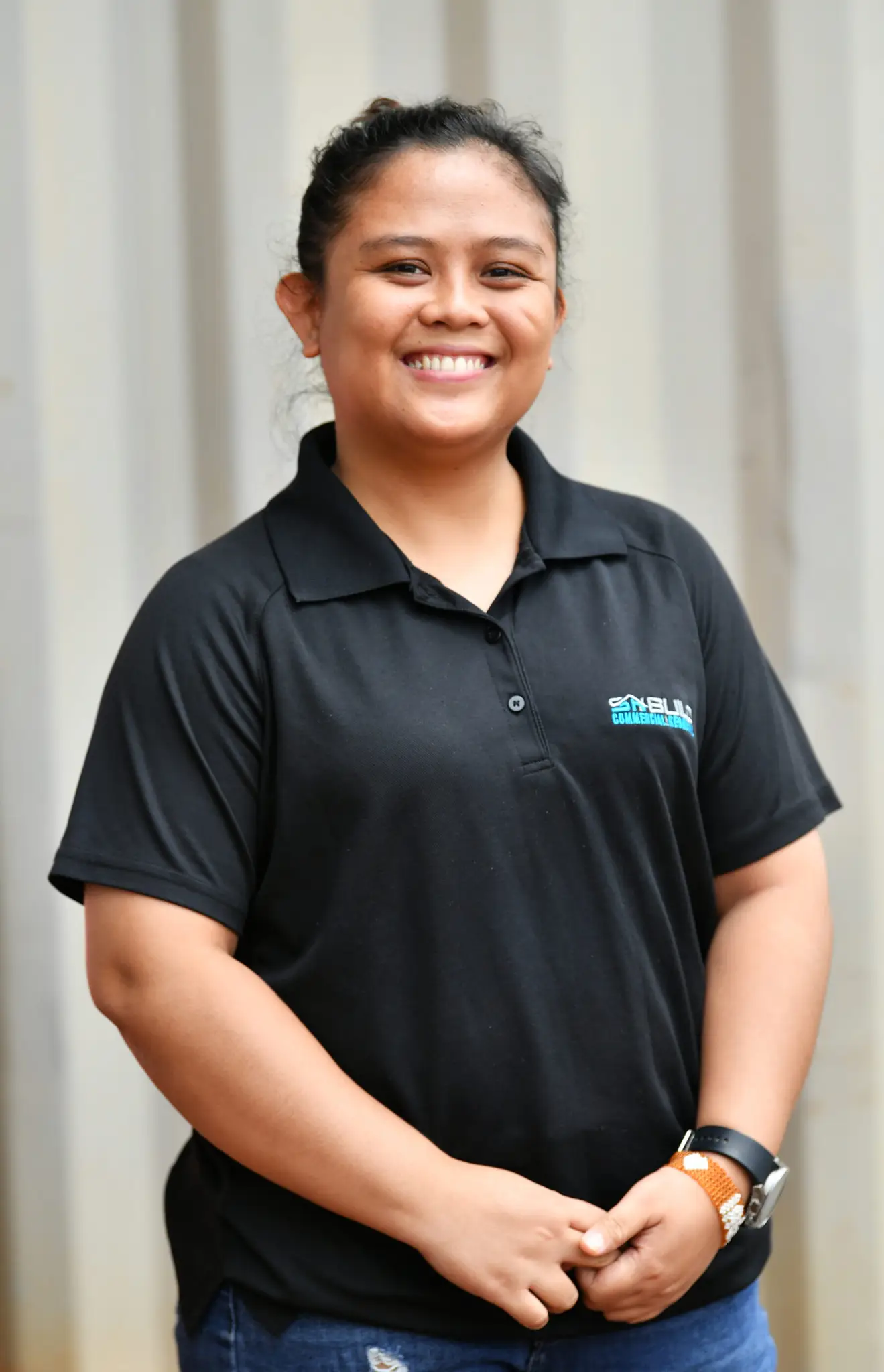 Smiling staff member in black company polo shirt